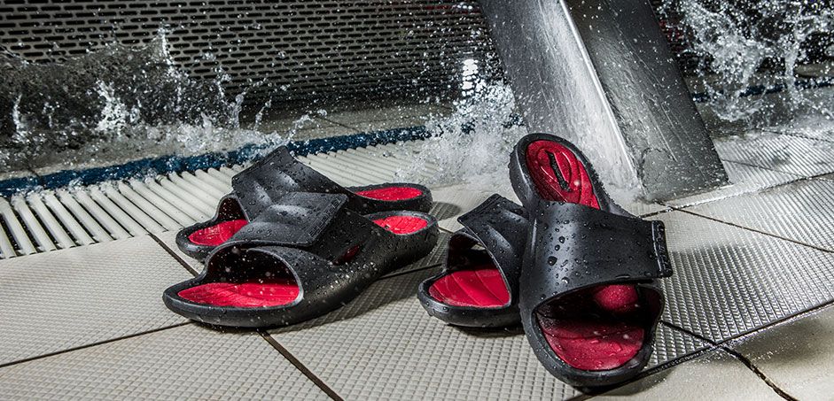 Zwei Paar Badeschuhe steht am Rand einer Schwimmbahn Zwei Paar Badeschuhe steht am Rand einer Schwimmbahn