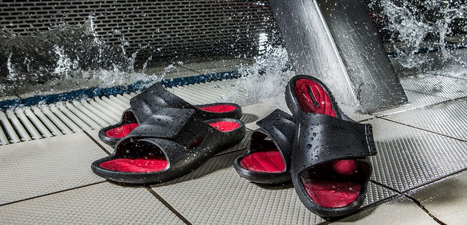 Zwei Paar Badeschuhe steht am Rand einer Schwimmbahn