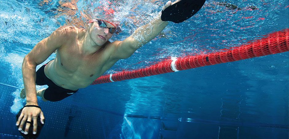 Unterwasseransicht eines Schwimmers, der Handflossen von Fashy trägt Unterwasseransicht eines Schwimmers, der Handflossen von Fashy trägt