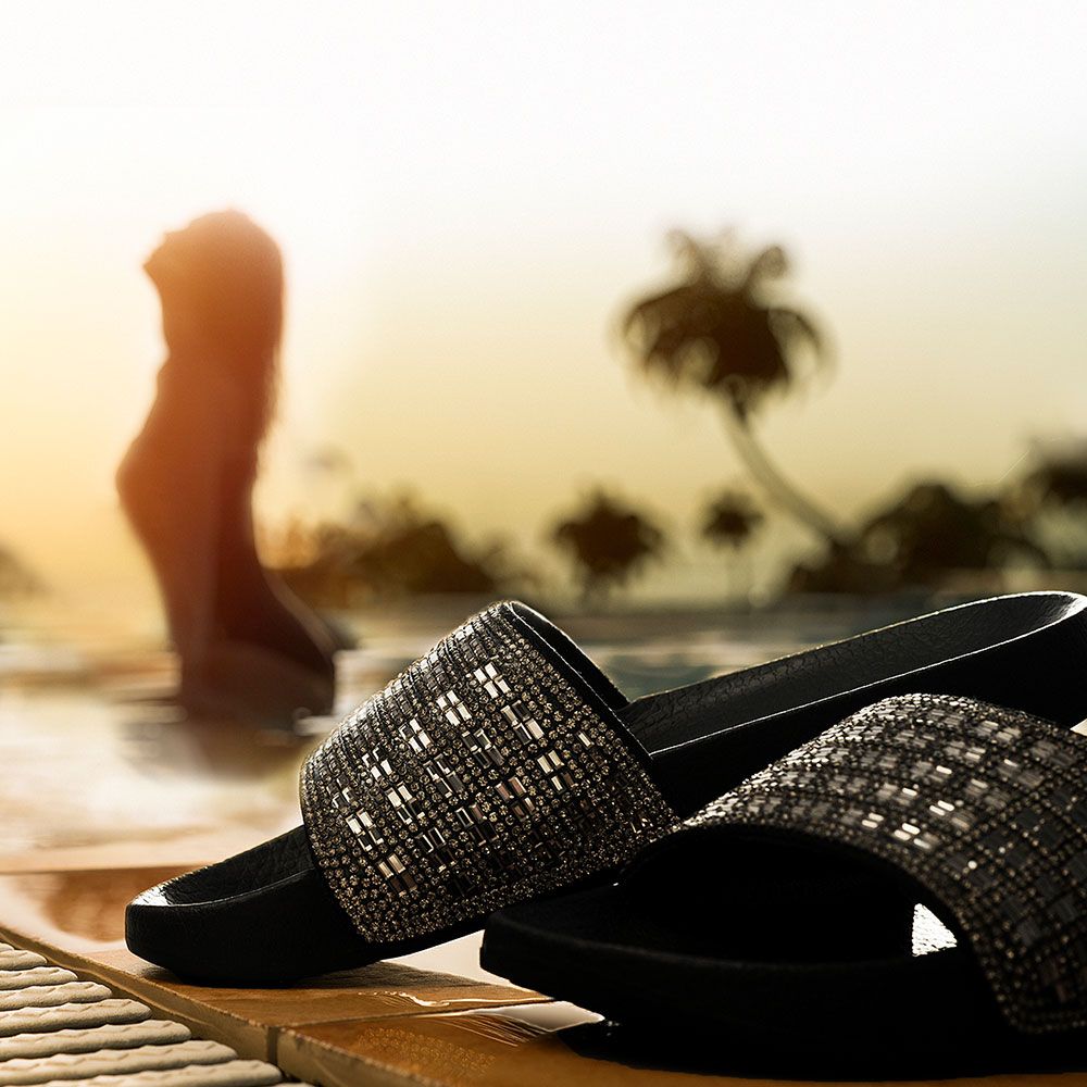Badeschuhe mit Sonneruntergang im Hintergrund Badeschuhe mit Sonneruntergang im Hintergrund
