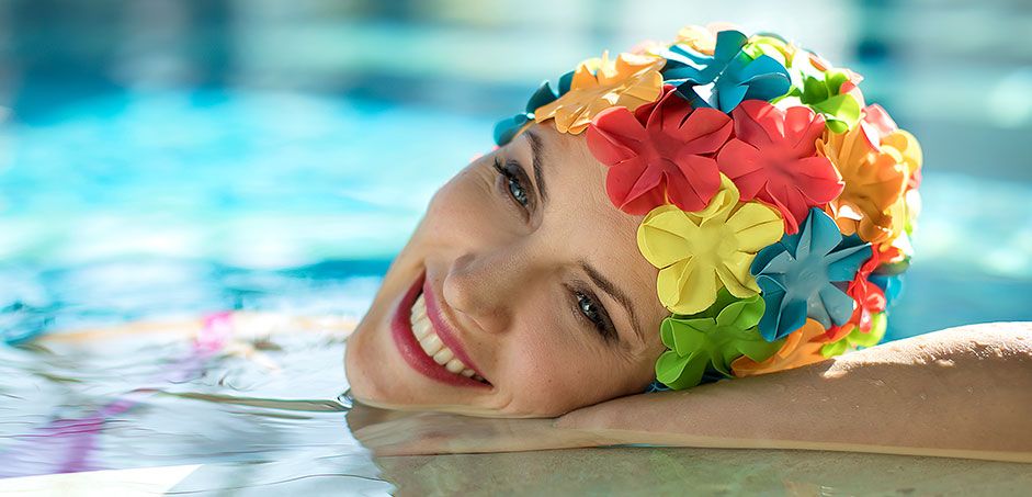 Eine Frau trägt eine bunte Bademütze mit Blumen